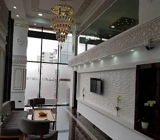 Zona de lounge a hotelului, cu fotolii și mese joase lângă ferestre