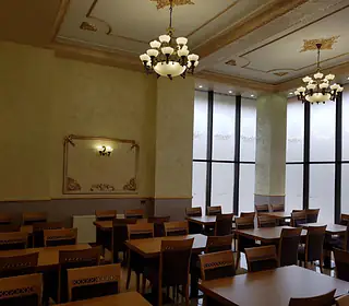 Sala Restaurantului Almita, cu mese de lemn și candelabre