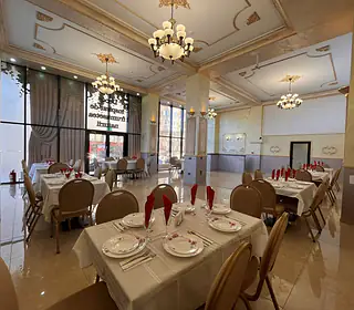Sala de evenimente a hotelului, cu mese aranjate și fețe de masă albe